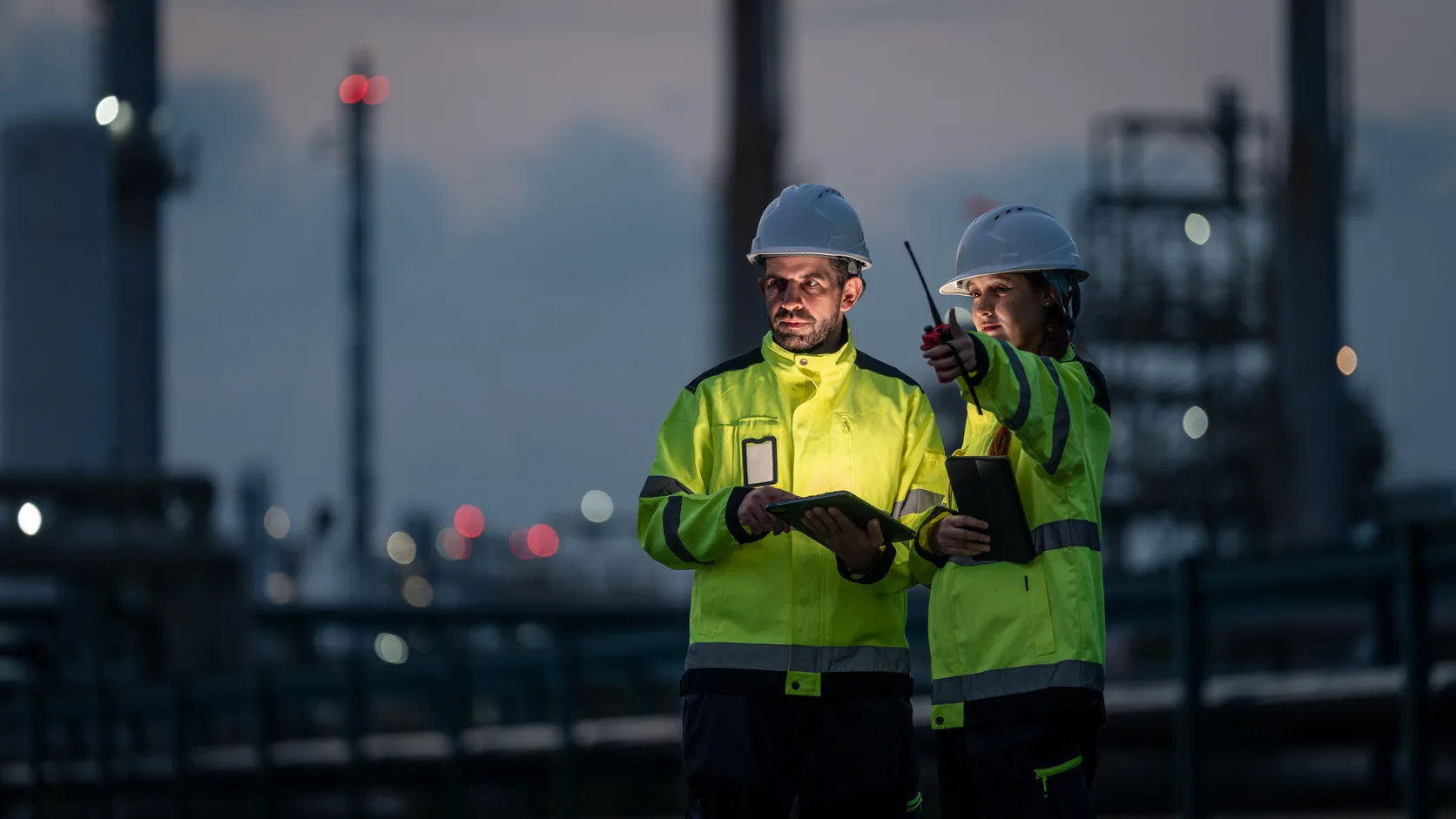 Dos profesionales comparten información en una instalación industrial.